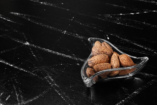 Cáscaras de almendras en una taza de vidrio.