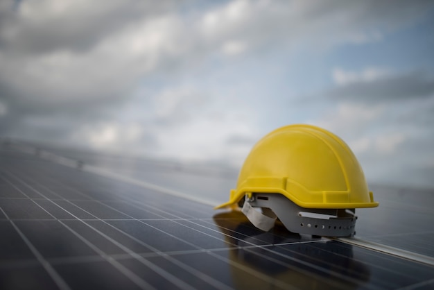 Casco de seguridad amarillo en el panel de la célula solar