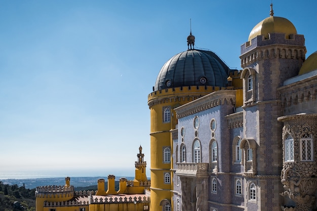 Castillo de Sintra Cascais rodeado de vegetación bajo la luz del sol y un cielo azul en Portugal