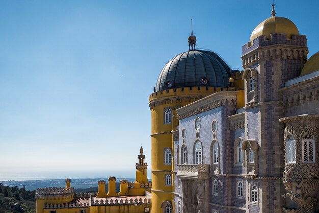 Castillo de Sintra Cascais rodeado de vegetación bajo la luz del sol y un cielo azul en Portugal