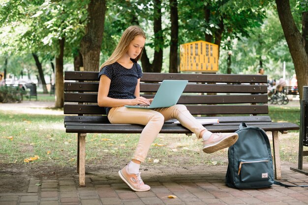 Casual adolescente estudiando con la computadora portátil