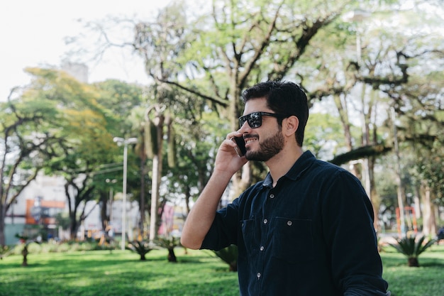 Casual hombre hablando por teléfono en el parque