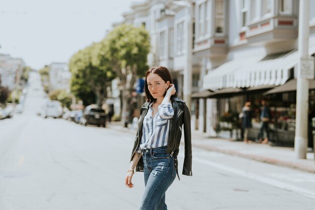 Casual mujer cruzando la calle en el centro, San Francisco