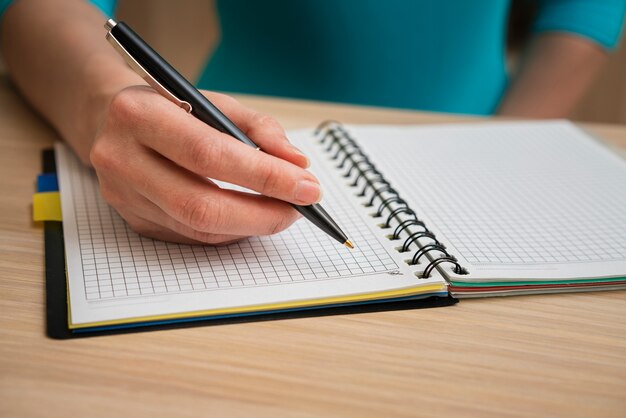 Casual mujer escribiendo en cuaderno cuadrado