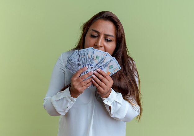 Casual mujer de mediana edad caucásica sosteniendo y mirando dinero