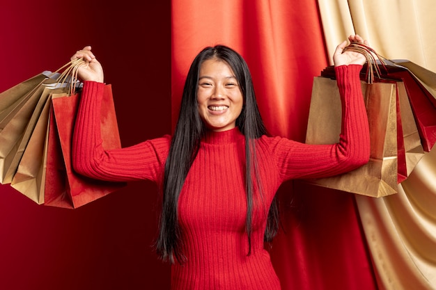 Foto gratuita casual mujer posando con bolsas de compras para el año nuevo chino