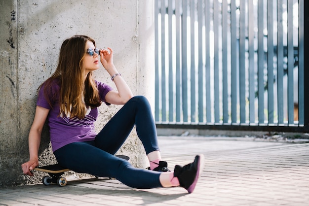 Casual mujer sentada en patineta