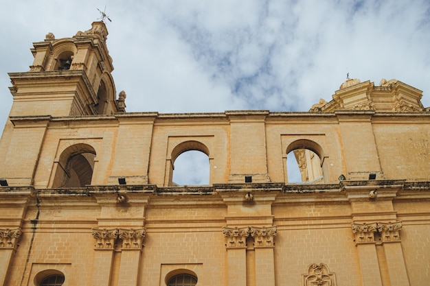 Catedral vieja con arcos y pilares de piedra con el cielo