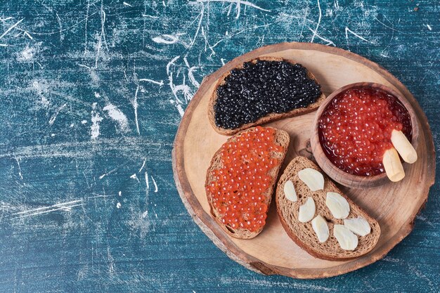 Caviar negro y rojo sobre una rebanada de pan.