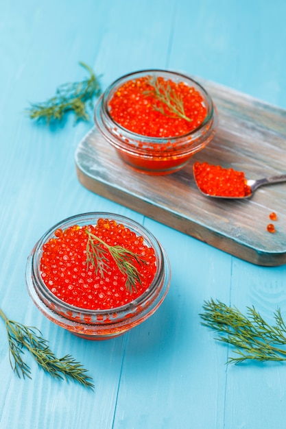 Caviar rojo en recipiente de vidrio y en una cuchara, vista superior