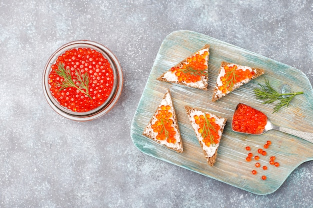 Foto gratuita caviar rojo en recipiente de vidrio y en una cuchara