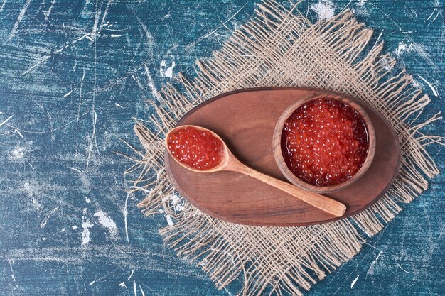 Caviar rojo sobre tabla de madera.