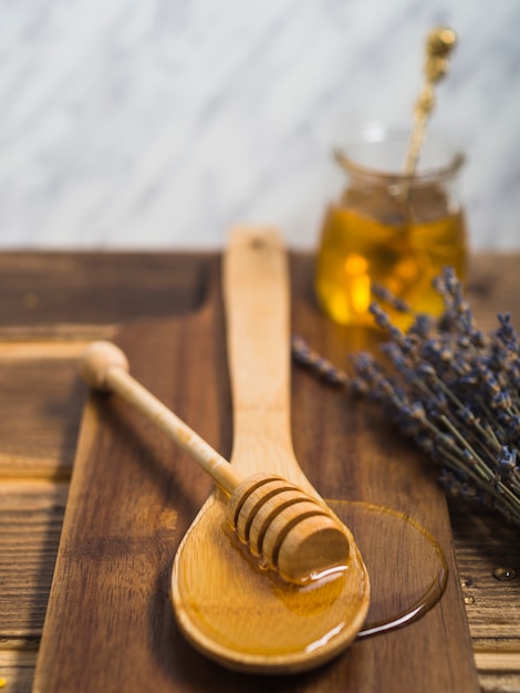 Foto gratuita cazo de miel en una cuchara de madera sobre la tabla de cortar