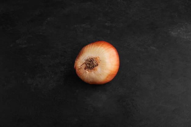 Una cebolla roja aislada sobre fondo negro.