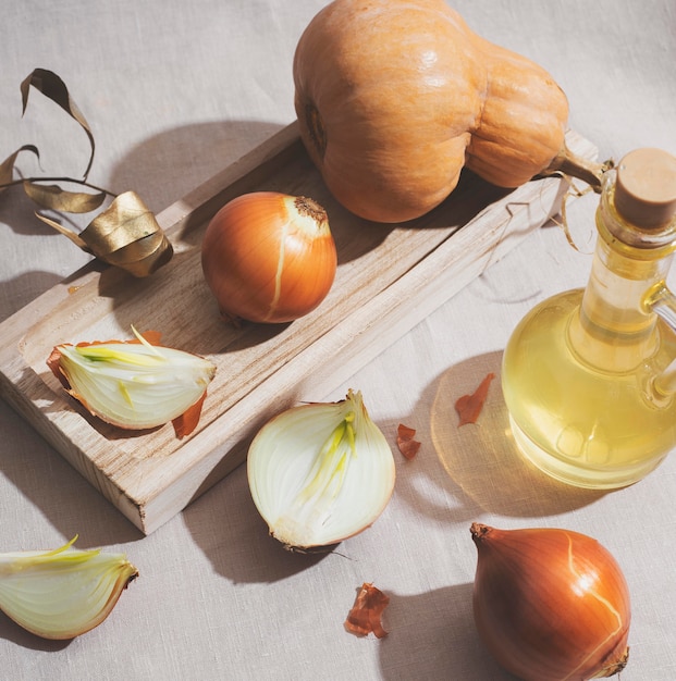 Cebollas y calabaza en ángulo alto de tablero de madera