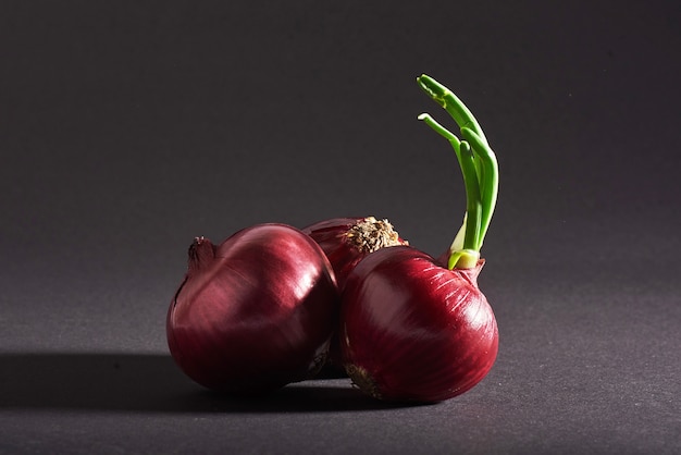 Foto gratuita cebollas rojas enteras, aisladas sobre un negro.