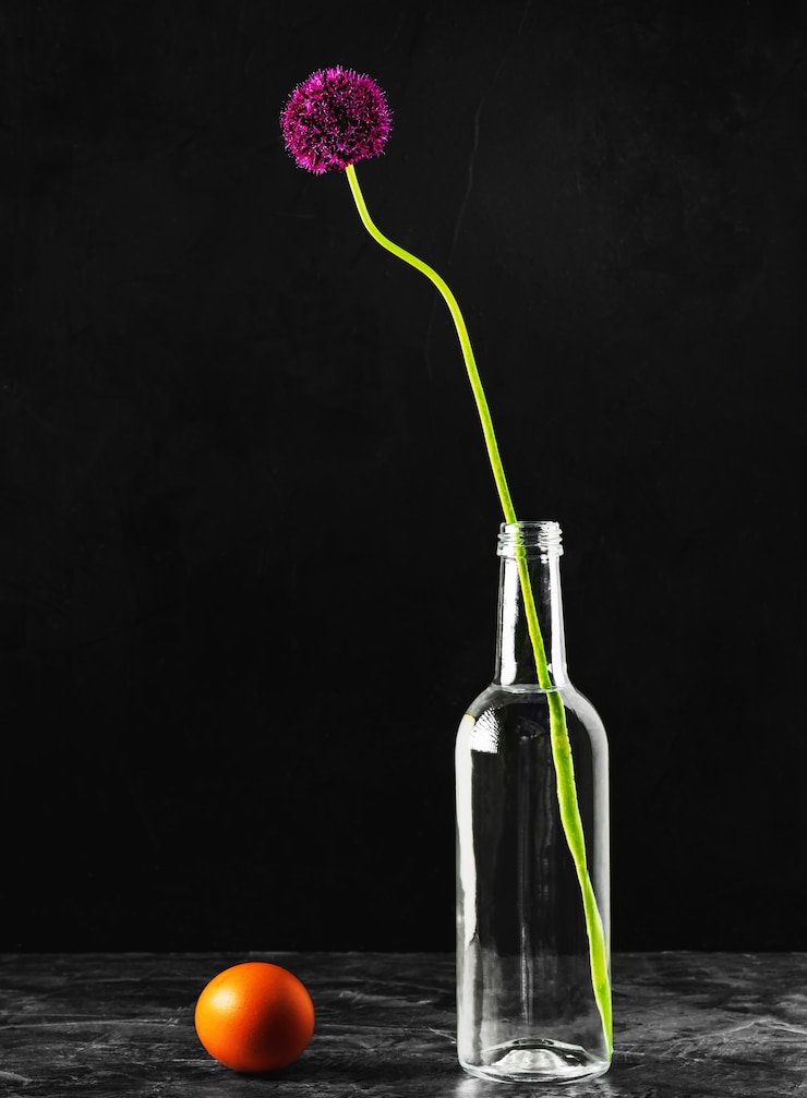 Foto gratuito cebollas silvestres en flor en una botella de agua de vidrio y huevo crudo