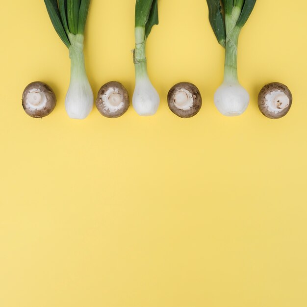 Cebollas verdes y champiñones en composición