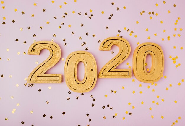 Celebración de año nuevo 2020 y estrellas de brillo dorado