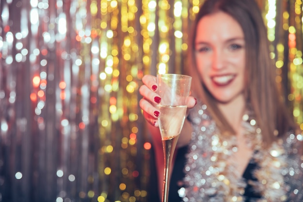 Celebración de año nuevo con chica enseñando vaso de champán