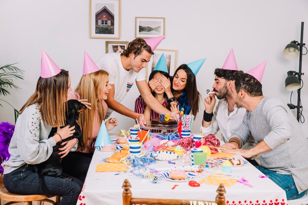 Celebración de cumpleaños con amigos alrededor de mesa