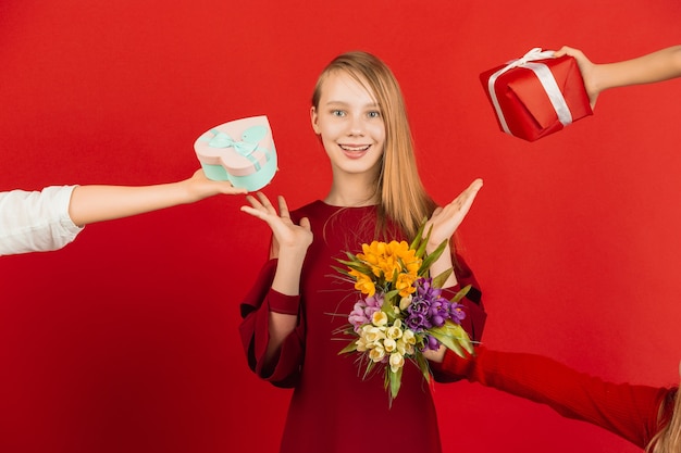 Celebración del día de San Valentín. Feliz, linda chica caucásica aislada sobre fondo rojo de estudio.