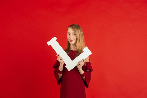 Celebración del día de San Valentín, feliz, linda chica caucásica con carta sobre fondo rojo de estudio.