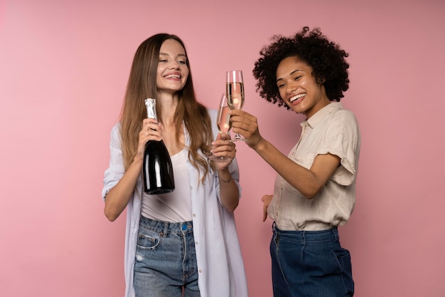 Celebración de mujeres con copas de champán y botella.