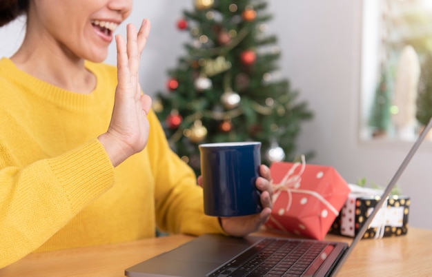 Celebración sonriente de la mujer de negocios de la fiesta de la oficina del día de Navidad que tiene videoconferencia