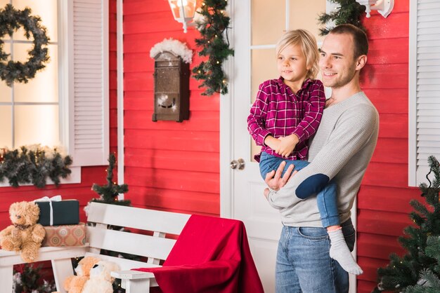 Celebraciones de navidad con hombre sujetando hija