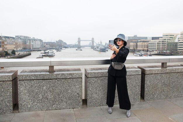 Celebridad de Internet haciéndose un selfie en un puente de la ciudad