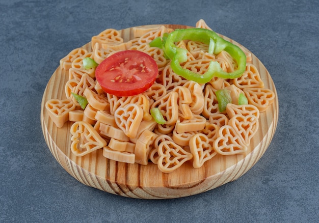 Cena casera con pasta y verduras en forma de corazón.