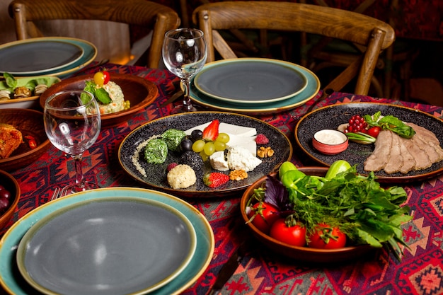 Una cena con guarnición y platos de ensalada.