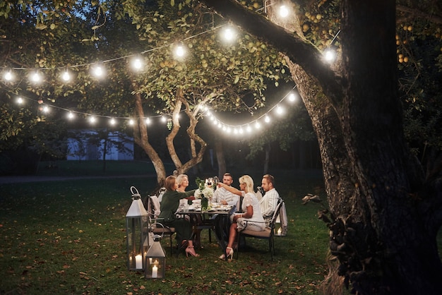 Cena de lujo Hora de la tarde Los amigos cenan en el hermoso lugar al aire libre.