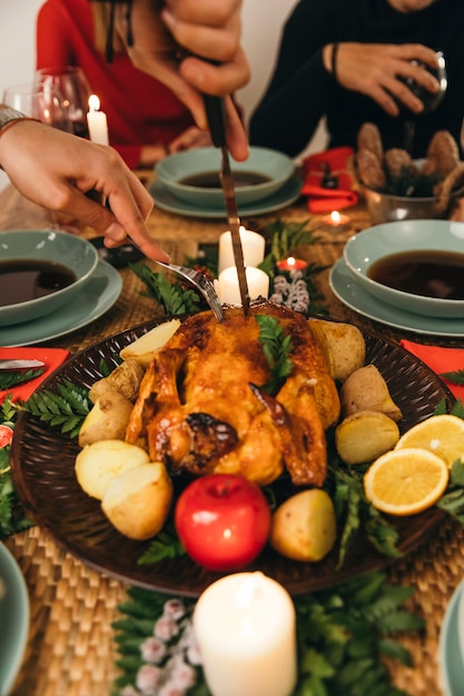 Foto gratuita cena de navidad con cuchillo cortando pavo