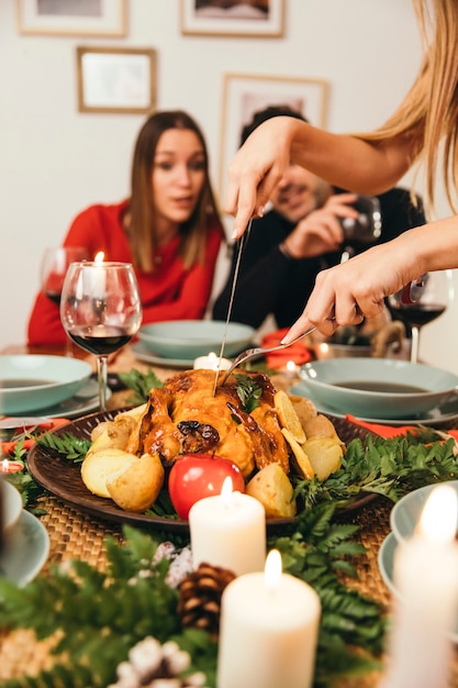 Foto gratuita cena de navidad con hombre cortando pavo