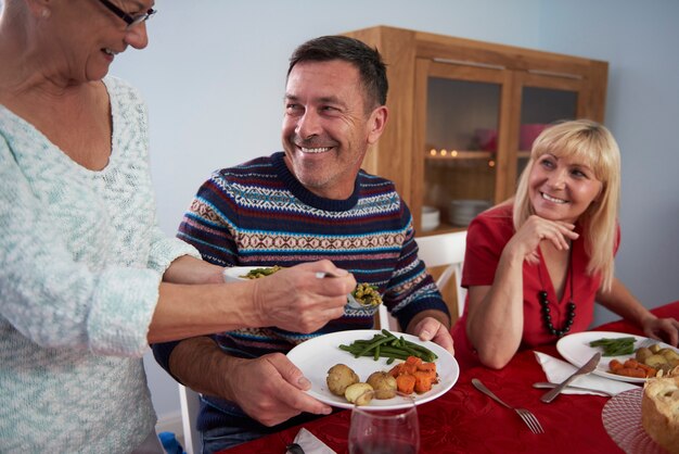 Cena de Navidad servida por la mujer mayor de la familia.