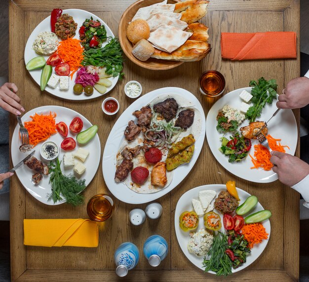 Cena en platos blancos que contienen carne y verduras,