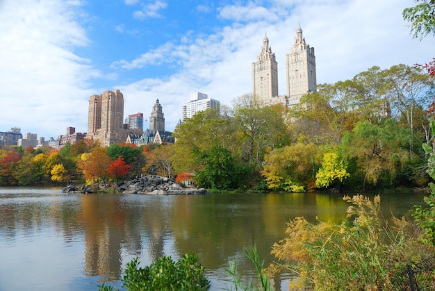 Central Park de la ciudad de Nueva York en otoño con rascacielos de Manhattan y árboles coloridos sobre el lago con reflejo.