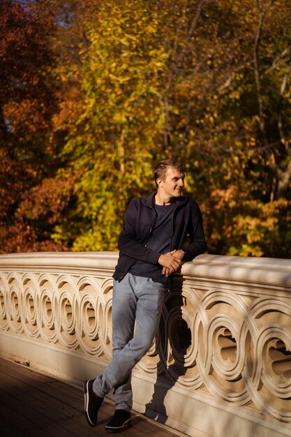 Central Park de Nueva York Manhattan en otoño, puente sobre el lago. un joven camina en un parque de otoño en Nueva York.