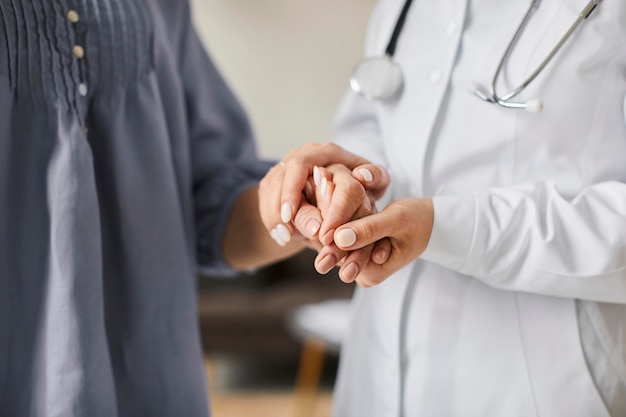 Centro de recuperación de covid doctora sosteniendo las manos del paciente anciano