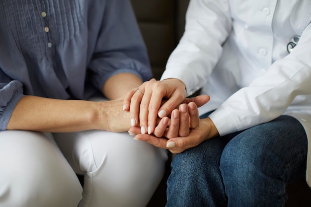 Centro de recuperación de covid doctora sosteniendo las manos del paciente anciano