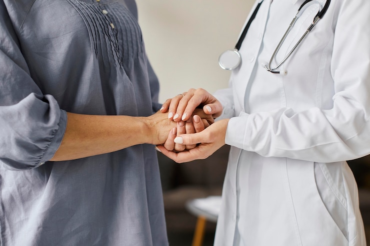 Foto gratuito centro de recuperación de covid doctora sosteniendo las manos del paciente mayor