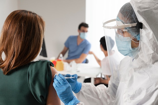 Foto gratuita centro de vacunación con médico sosteniendo una jeringa