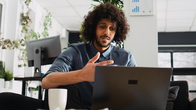 El CEO de una startup asiste a una reunión de negocios con conexión de videoconferencia, utilizando una llamada de videoconference en línea para explicar la solución de la compañía para el desarrollo.