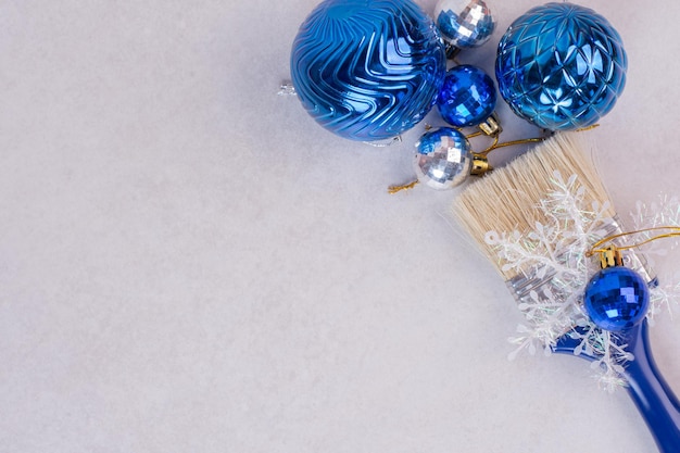 Cepillo azul con bolas de Navidad en el cuadro blanco.