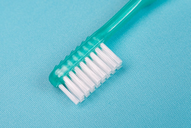Cepillo de dientes verde sobre la mesa azul