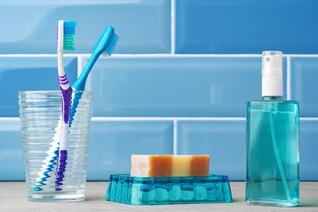 Los cepillos de dientes en un vaso en el baño azul