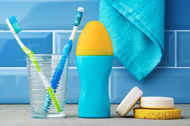 Los cepillos de dientes en un vaso en el baño azul