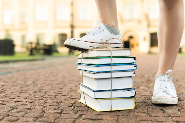 Foto gratuita cerca de adolescente pisando libros